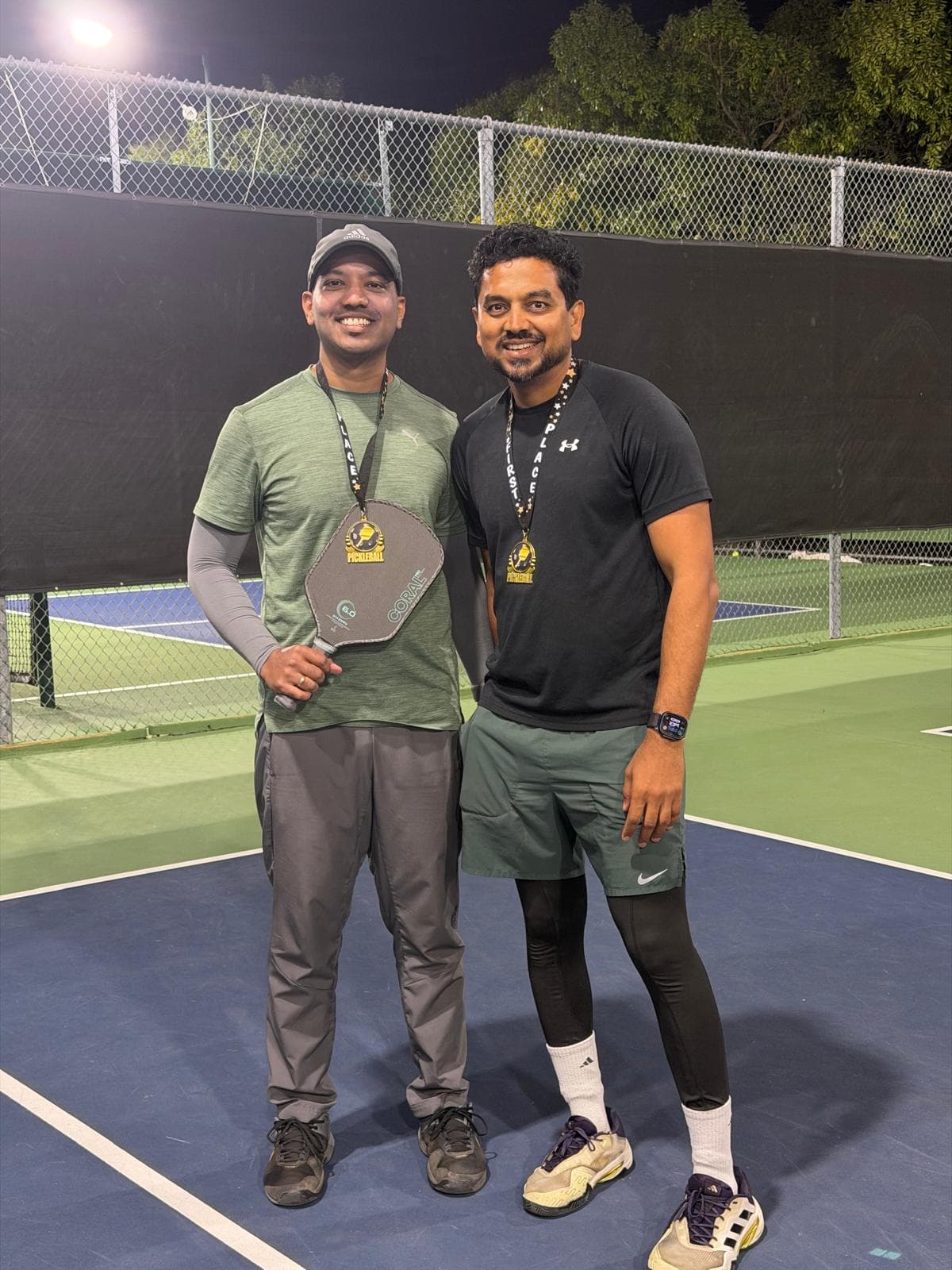 Jaynesh and Basavraj, Intermediate champions, wearing their first-place medals on court.